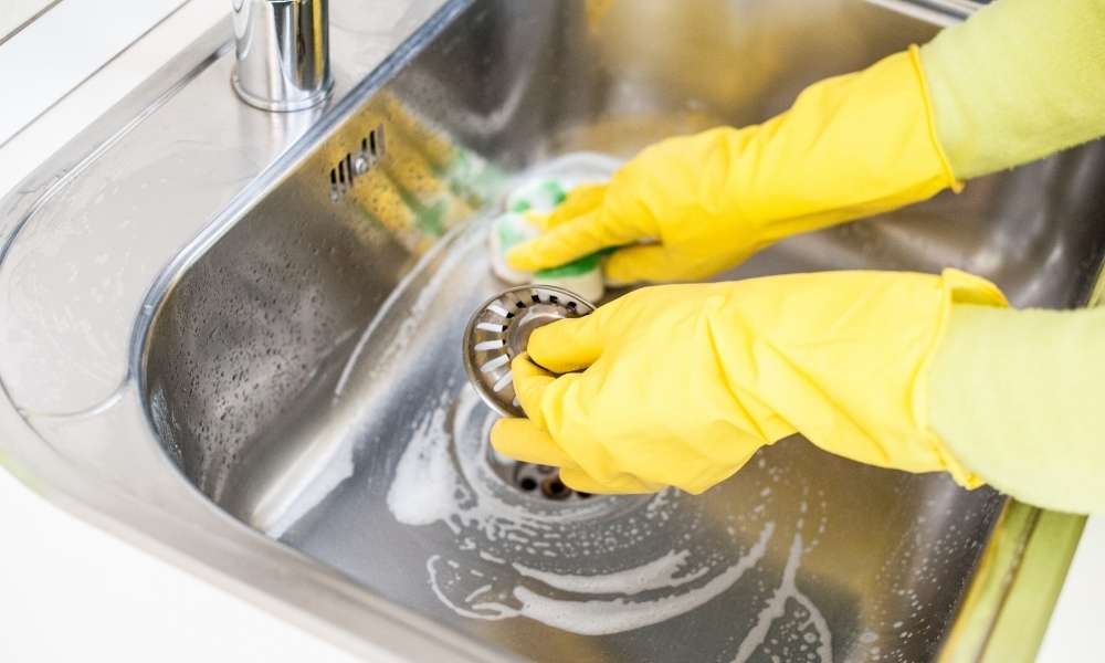 Scrubbing kitchen sink to clean